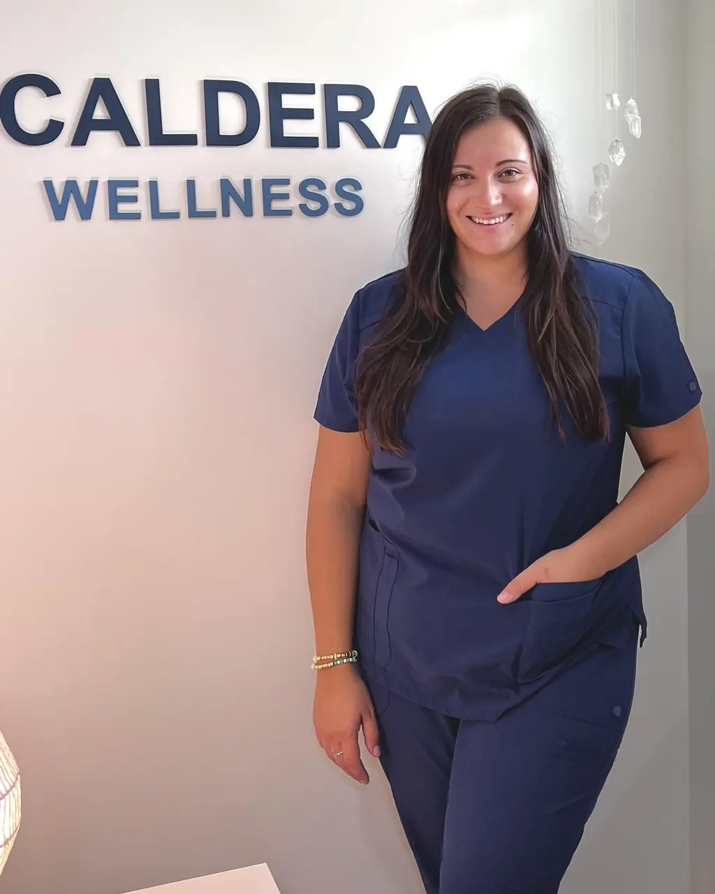 Brianna Del Vecchio, LAc, LMT, smiling in the Caldera Wellness studio