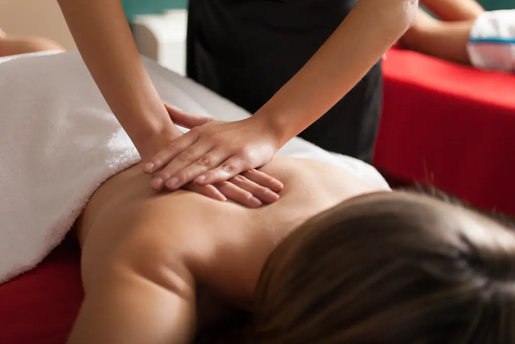A massage therapist working on a client's upper back